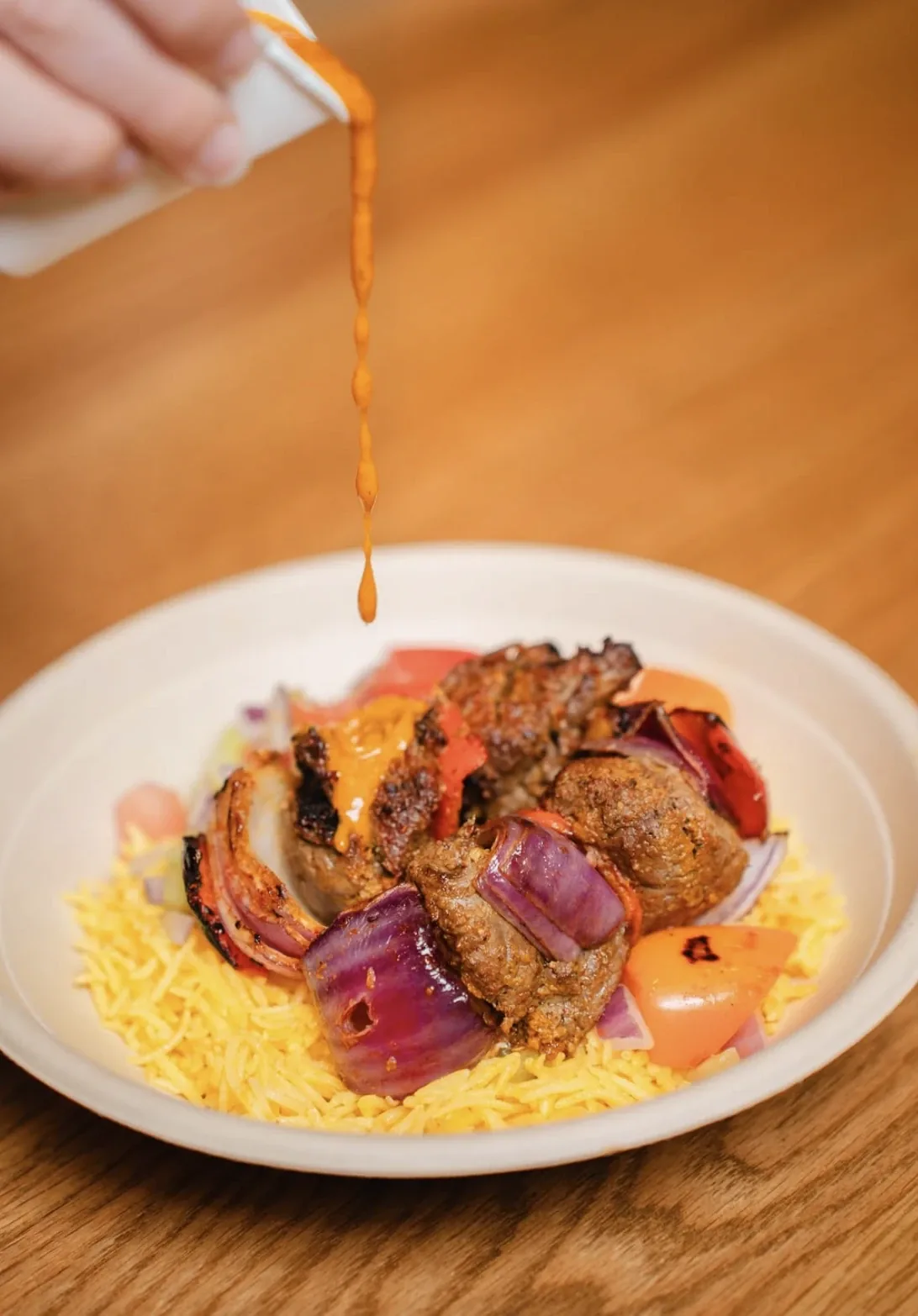 A daily meal plated over rice, sauce poured on top