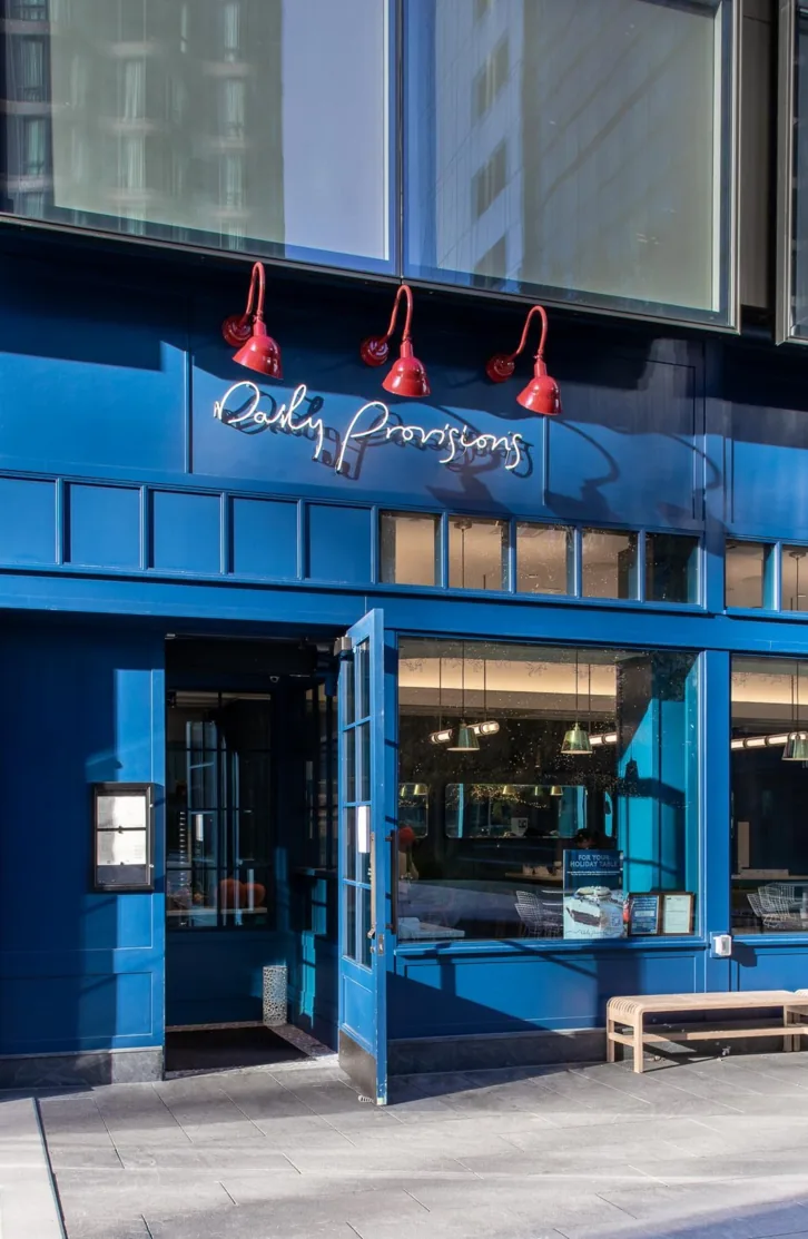 The Daily Provisions storefront in blue with red lamps